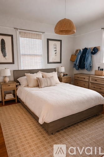 A bedroom with a large bed, a wooden nightstand, and a hanging light fixture.