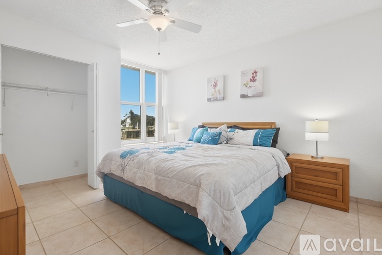 A bedroom with a bed, nightstand, and a ceiling fan.