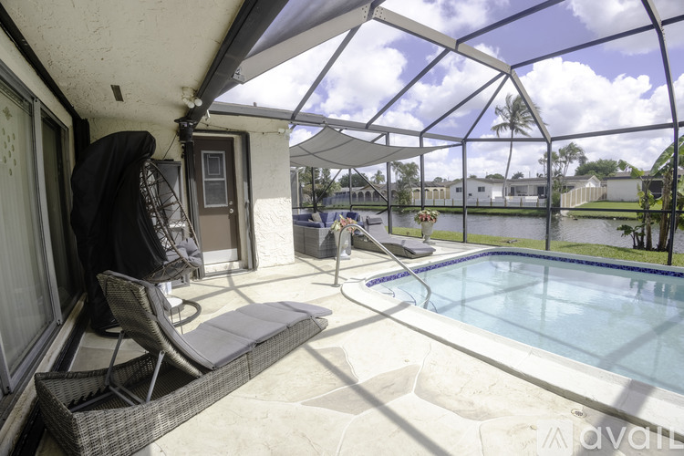 A patio with a hot tub and chairs.