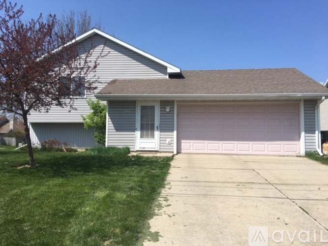 A house with a grey roof and a pink garage door.