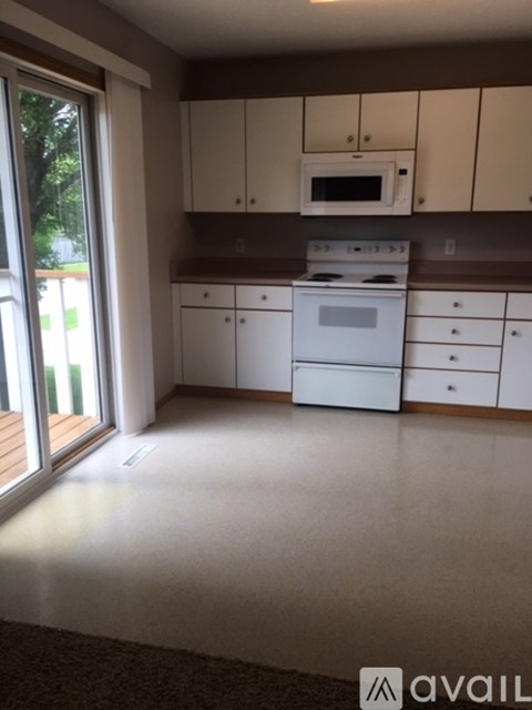 A kitchen with white cabinets and appliances.