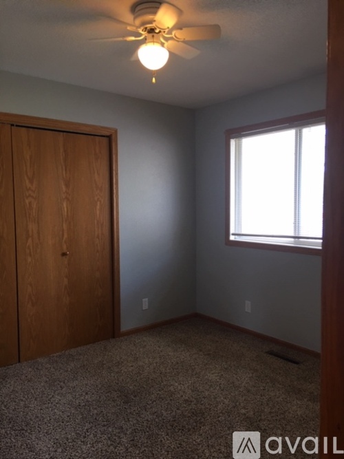 A room with a ceiling fan and a window.