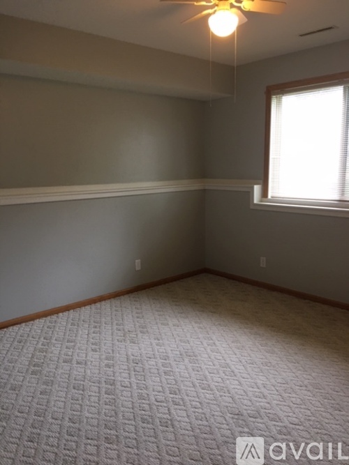 A room with a carpeted floor and a window.