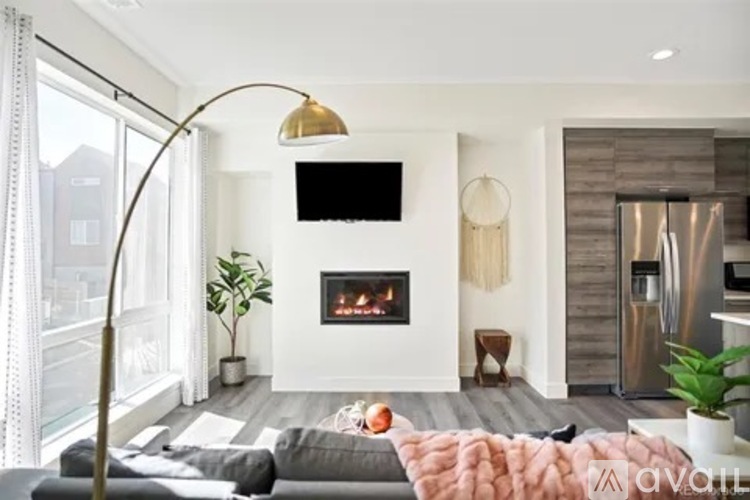 A modern living room with a fireplace and a flat screen TV mounted on the wall.