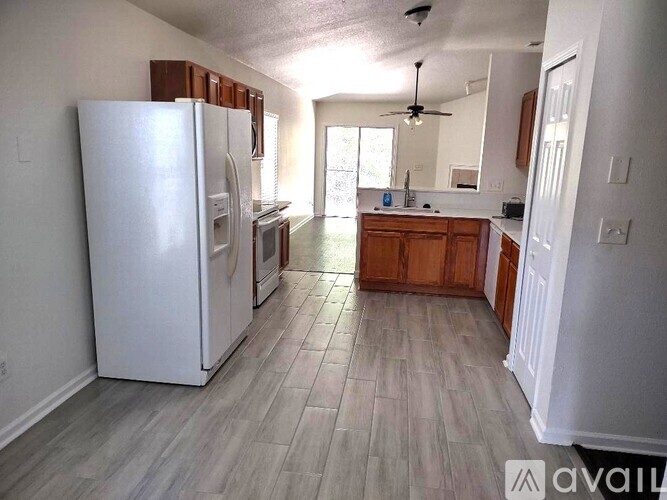 A kitchen with a white fridge and wooden cabinets.