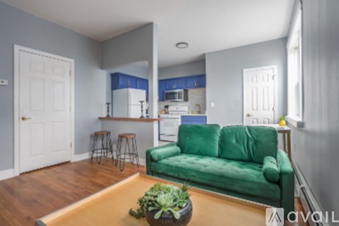 A living room with a green couch and a wooden table.