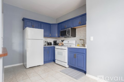 A kitchen with blue cabinets and white appliances.