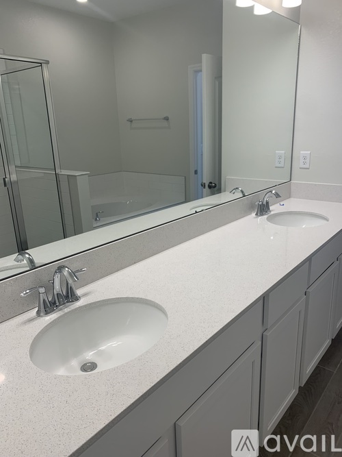 A bathroom with two sinks and a large mirror.