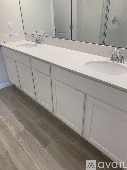 A bathroom with two sinks and a large mirror.