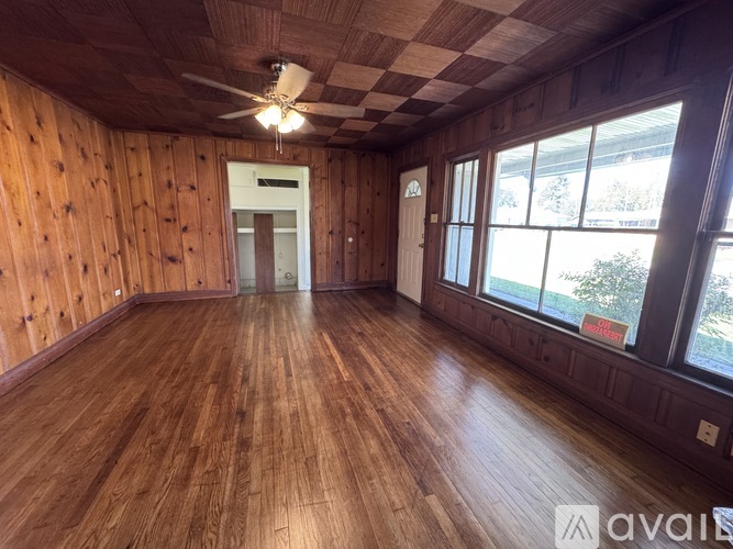 A room with wooden floors and a ceiling fan.