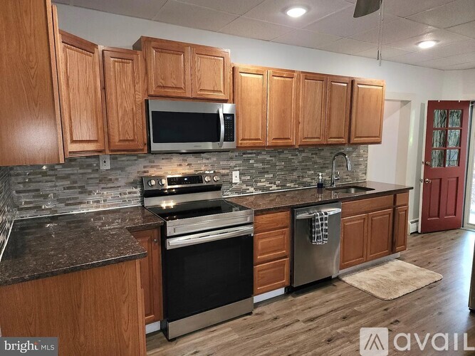 A kitchen with wooden cabinets and a black stove top oven.