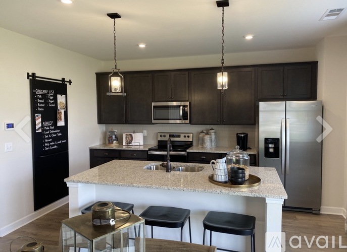 A kitchen with a black and white color scheme and a refrigerator on the right.