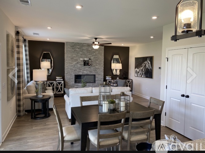 A modern dining room with a stone fireplace and a glass table.