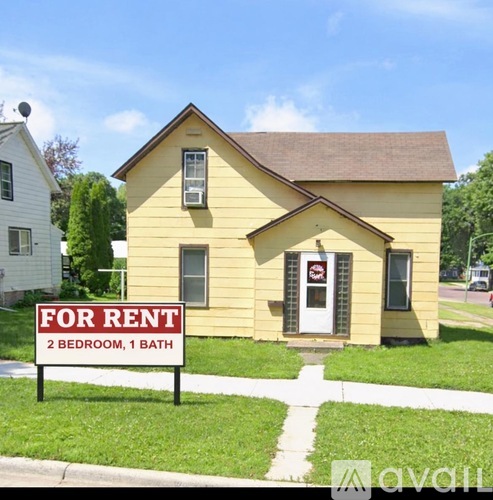 A yellow house is for rent with two bedrooms and one bath.