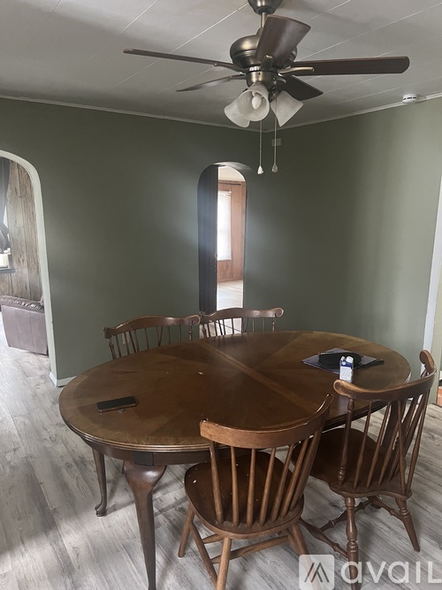 A dining room with a wooden table and chairs.