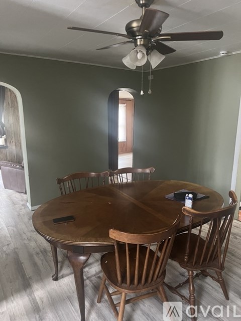 A dining room with a wooden table and chairs.