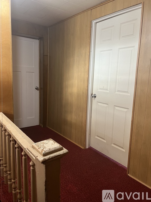 A hallway with two doors and a carpeted floor.