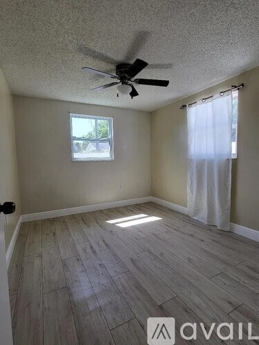 A room with a ceiling fan and a window.