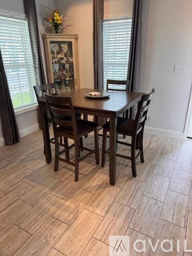 A dining room with a wooden table and chairs.
