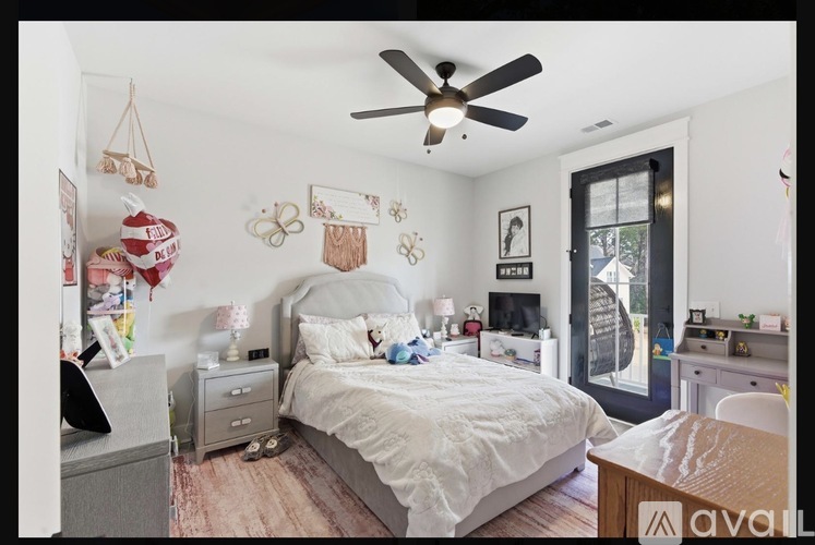 A bedroom with a bed, dresser, and ceiling fan.