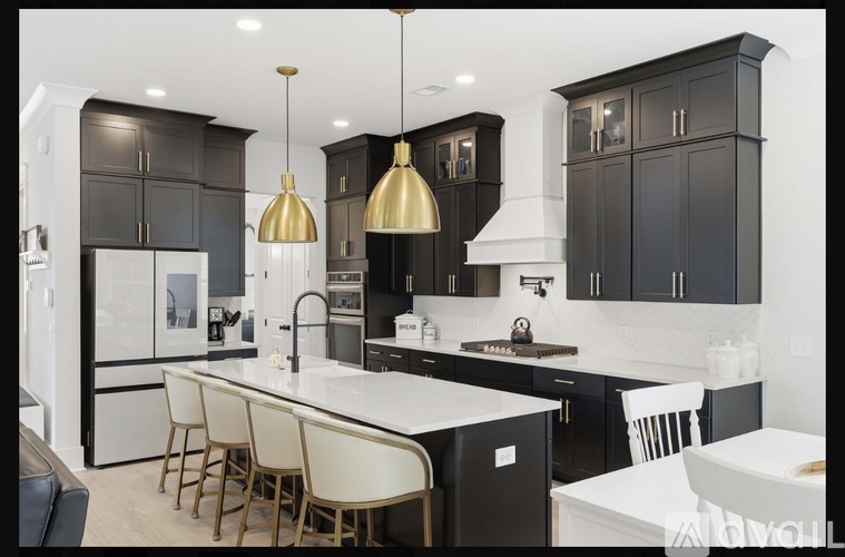 A modern kitchen with dark brown cabinets and white countertops.