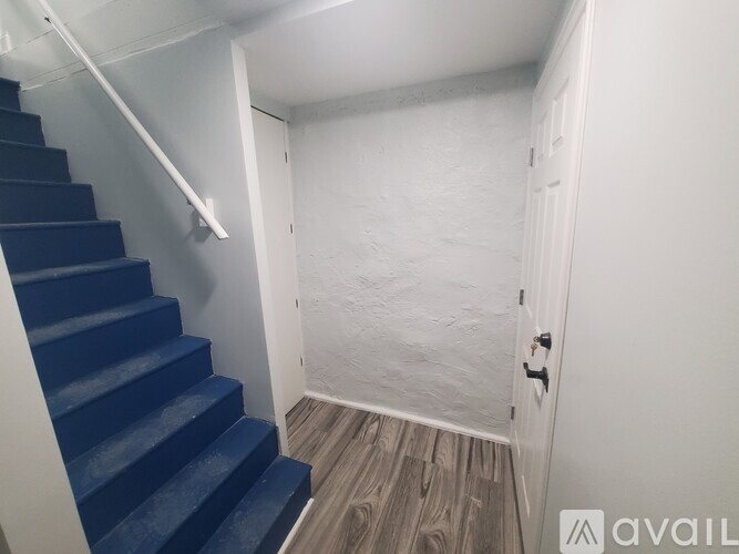A staircase with blue steps leads to a white door.