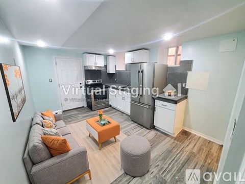 A living room with a grey couch and a coffee table with an orange top.
