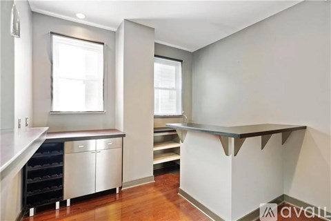 A kitchen with a white counter top and stainless steel appliances.
