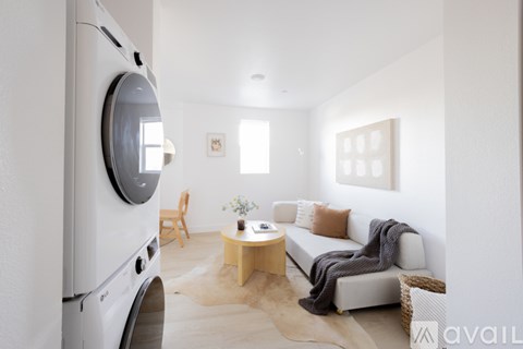 A modern living room with a white sofa and a wooden coffee table.