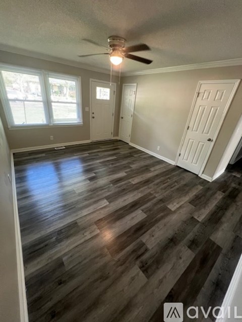 A room with wooden flooring and a ceiling fan.
