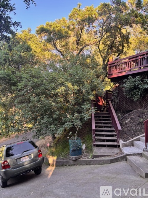 A car is parked on a driveway leading to a staircase.