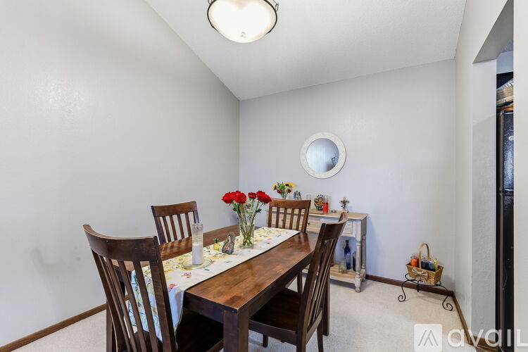 A dining room with a wooden table and chairs.