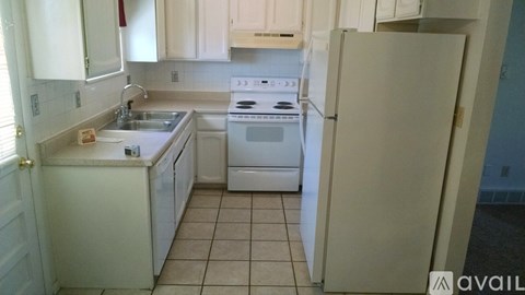 A kitchen with white appliances and cabinets.