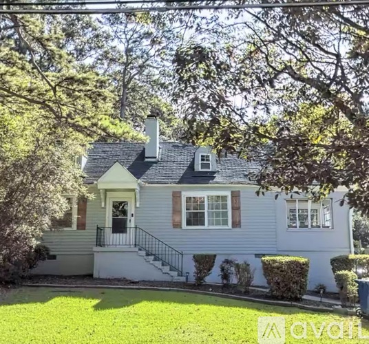 A house with a grey siding and a white front porch.