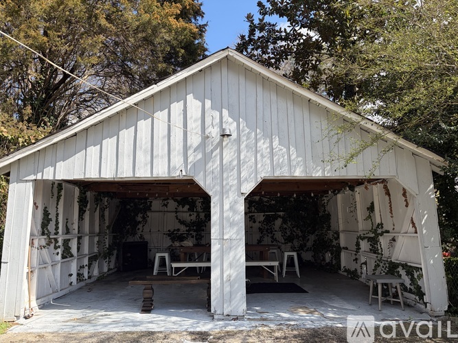 A white wooden building with a roof and a sign that says "available" in front.