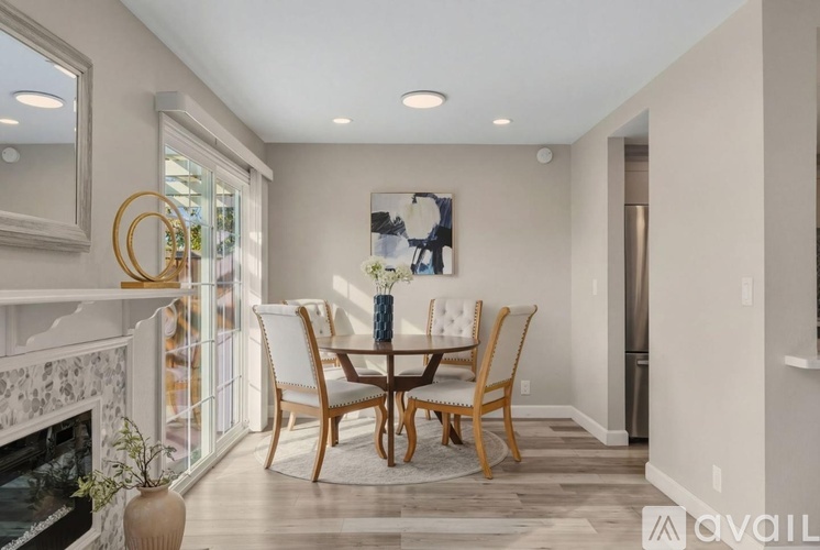 A dining room with a wooden table and chairs.