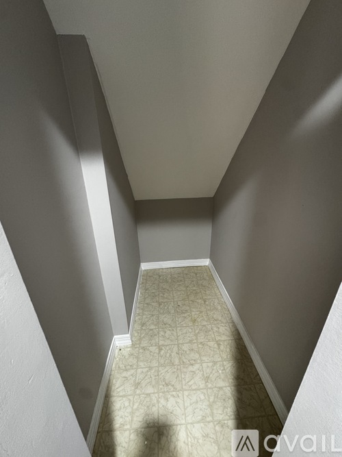 A hallway with a tiled floor and white walls.