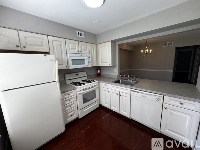 A kitchen with white appliances and cabinets.