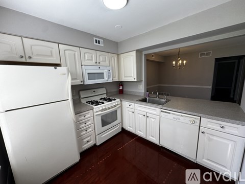 A kitchen with white appliances and cabinets.