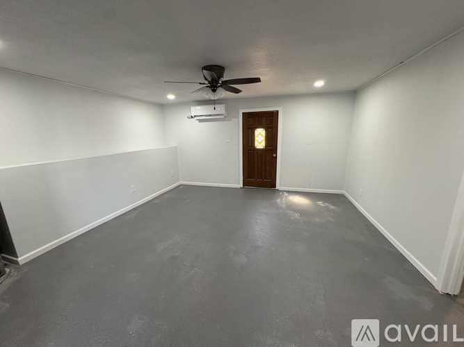 A room with a ceiling fan and a door.
