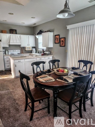 A kitchen with a table and chairs set for four.