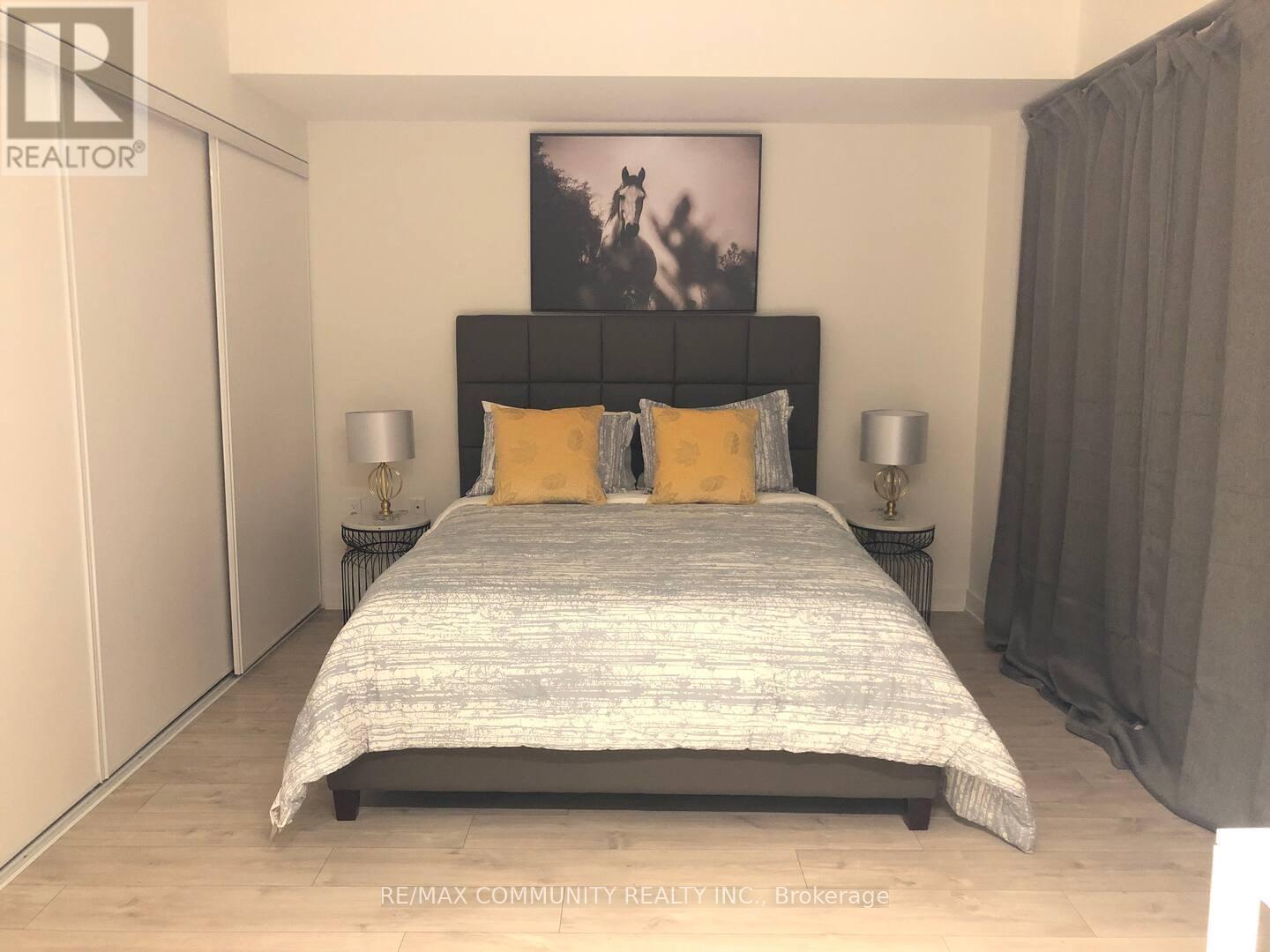 A bedroom with a large bed and a painting on the wall.