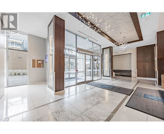 The image shows the lobby of a building with a glass wall and a brown door.