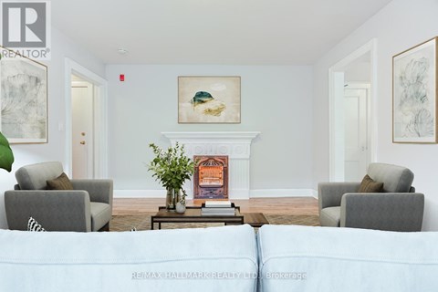 A living room with a fireplace and a painting on the wall.
