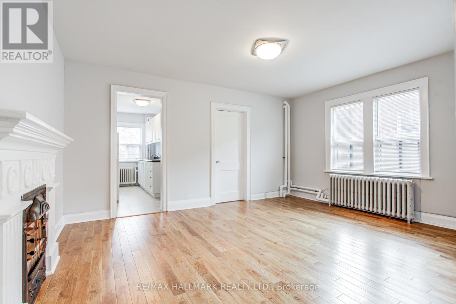 A spacious room with wooden floors and white walls.