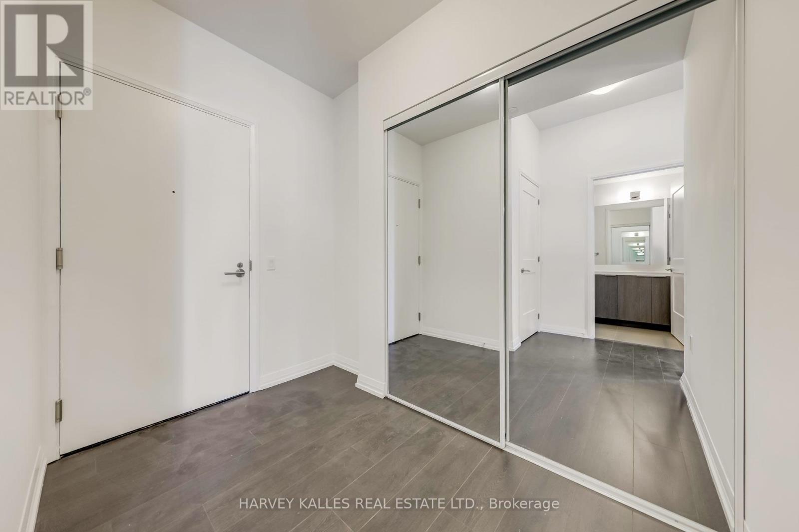 A spacious room with a sliding glass door leading to another room.