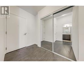 A spacious room with a sliding glass door leading to another room.