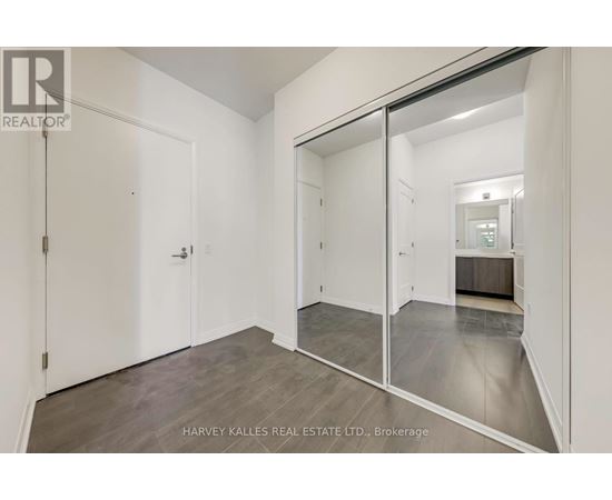 A spacious room with a sliding glass door leading to another room.