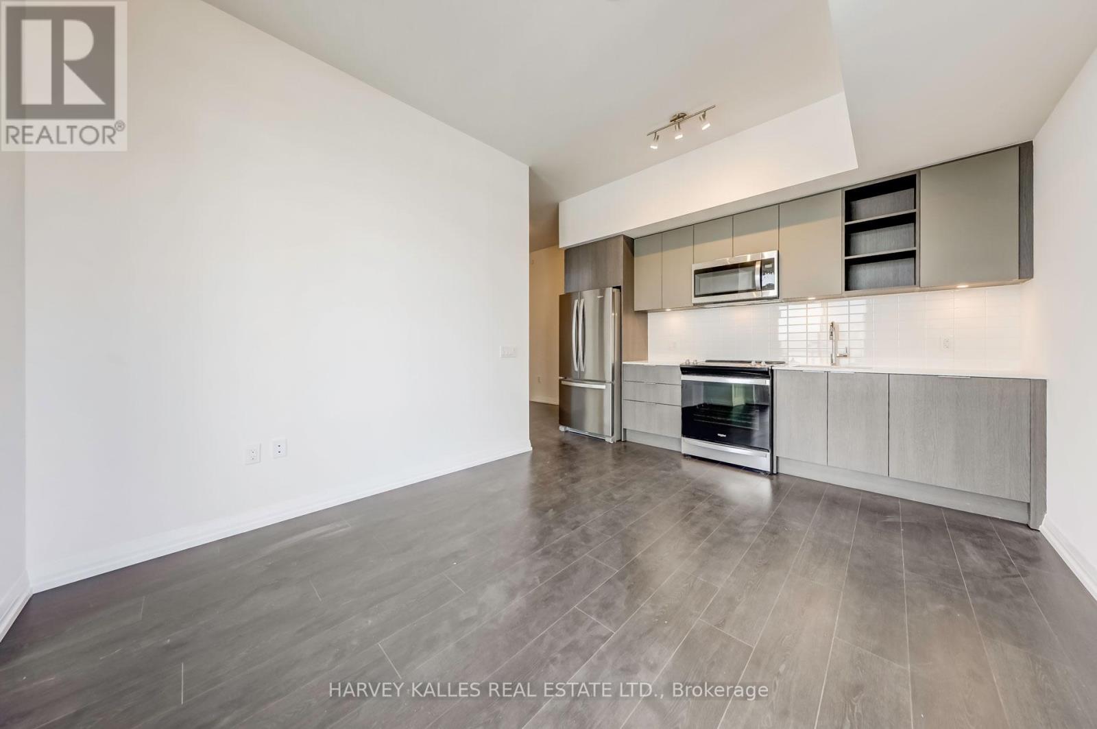 A spacious kitchen with a refrigerator, oven, and microwave.