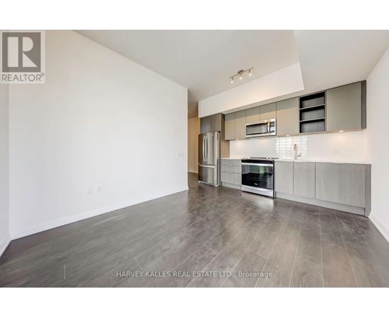 A spacious kitchen with a refrigerator, oven, and microwave.